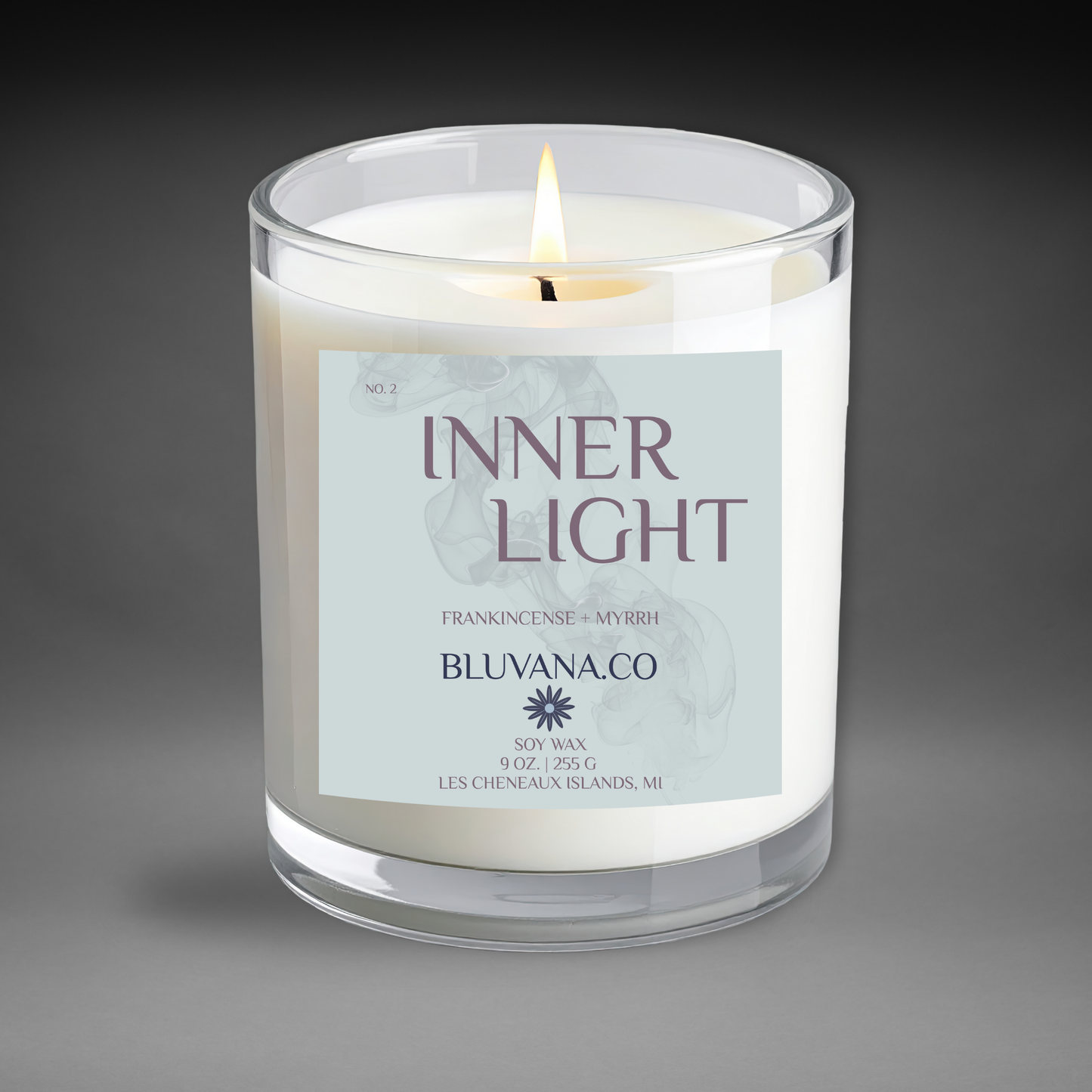 Candle in a glass jar with a label reading 'Inner Light' by Bluvana.co on a gray background