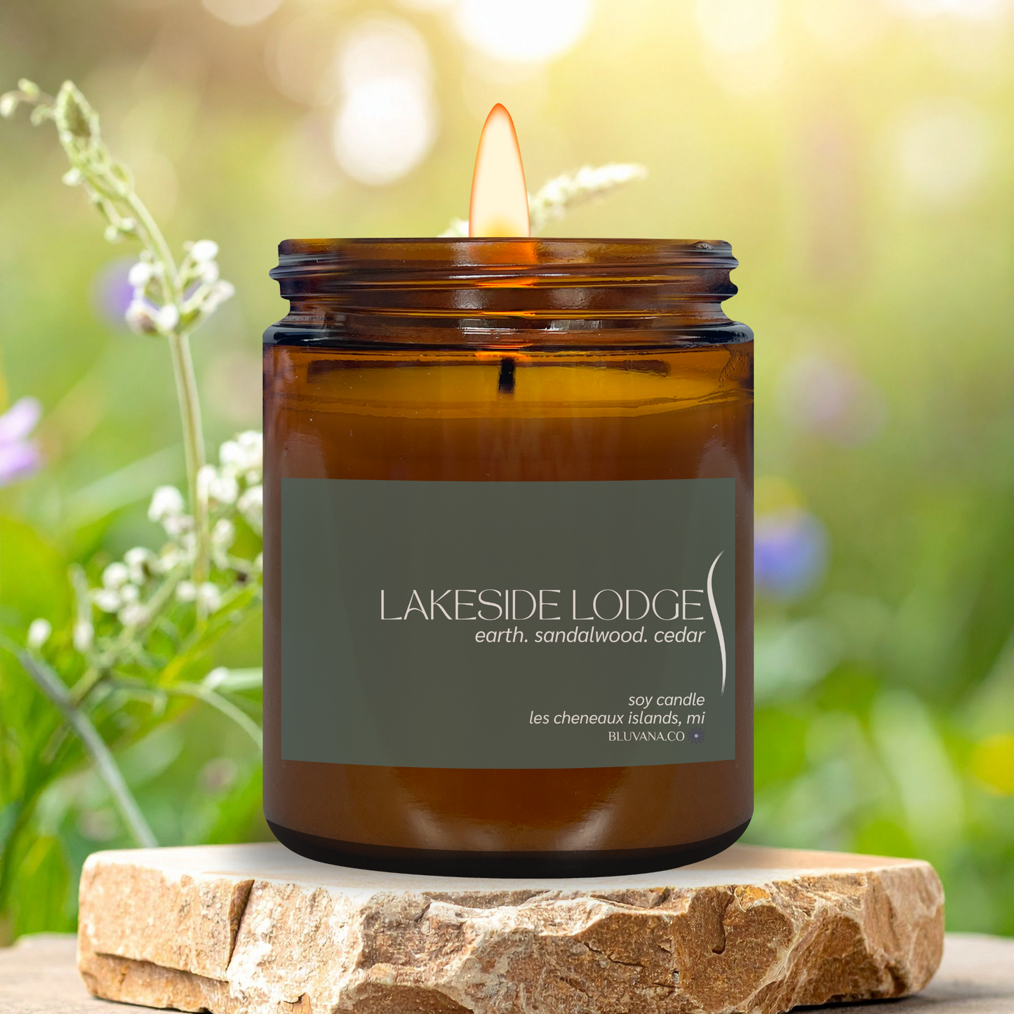Coastal Cottage candle in an amber jar with a label, set against a natural background.