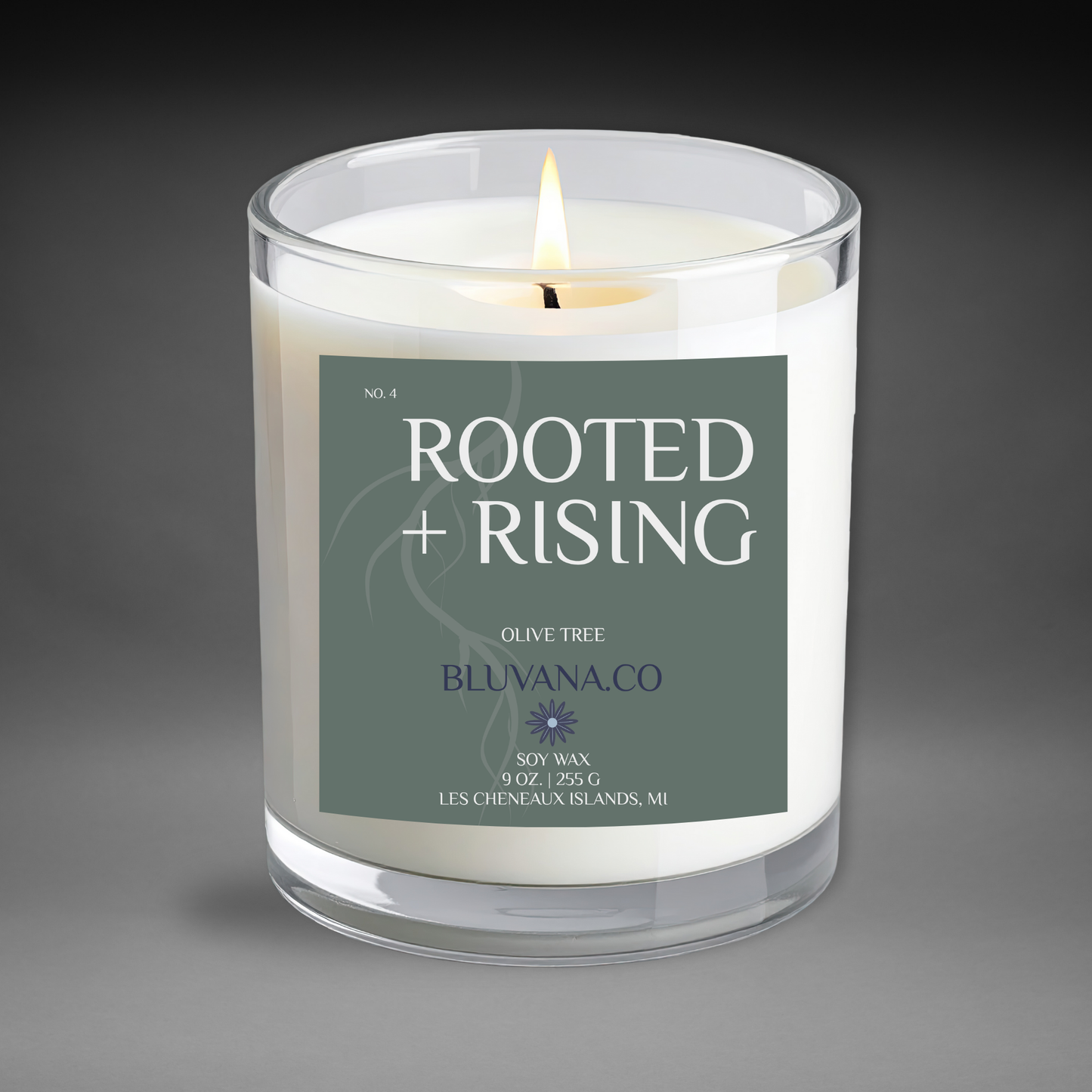Candle with 'Rooted + Rising' label on a gray background