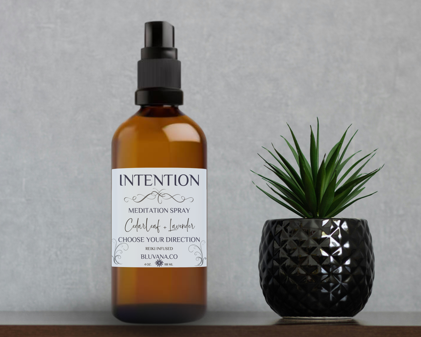 Meditation spray bottle labeled 'Intention' next to a potted plant on a gray background