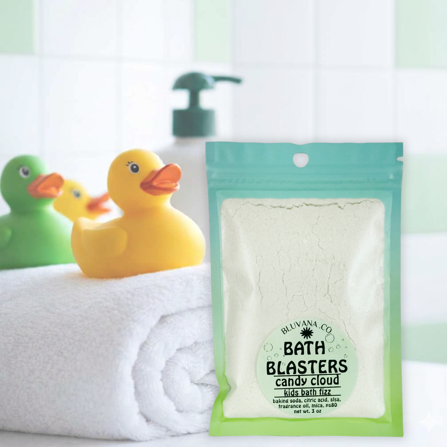 Image of a package of kids bath fizz sitting on the edge of a bathtub with a towel and rubber ducky. 