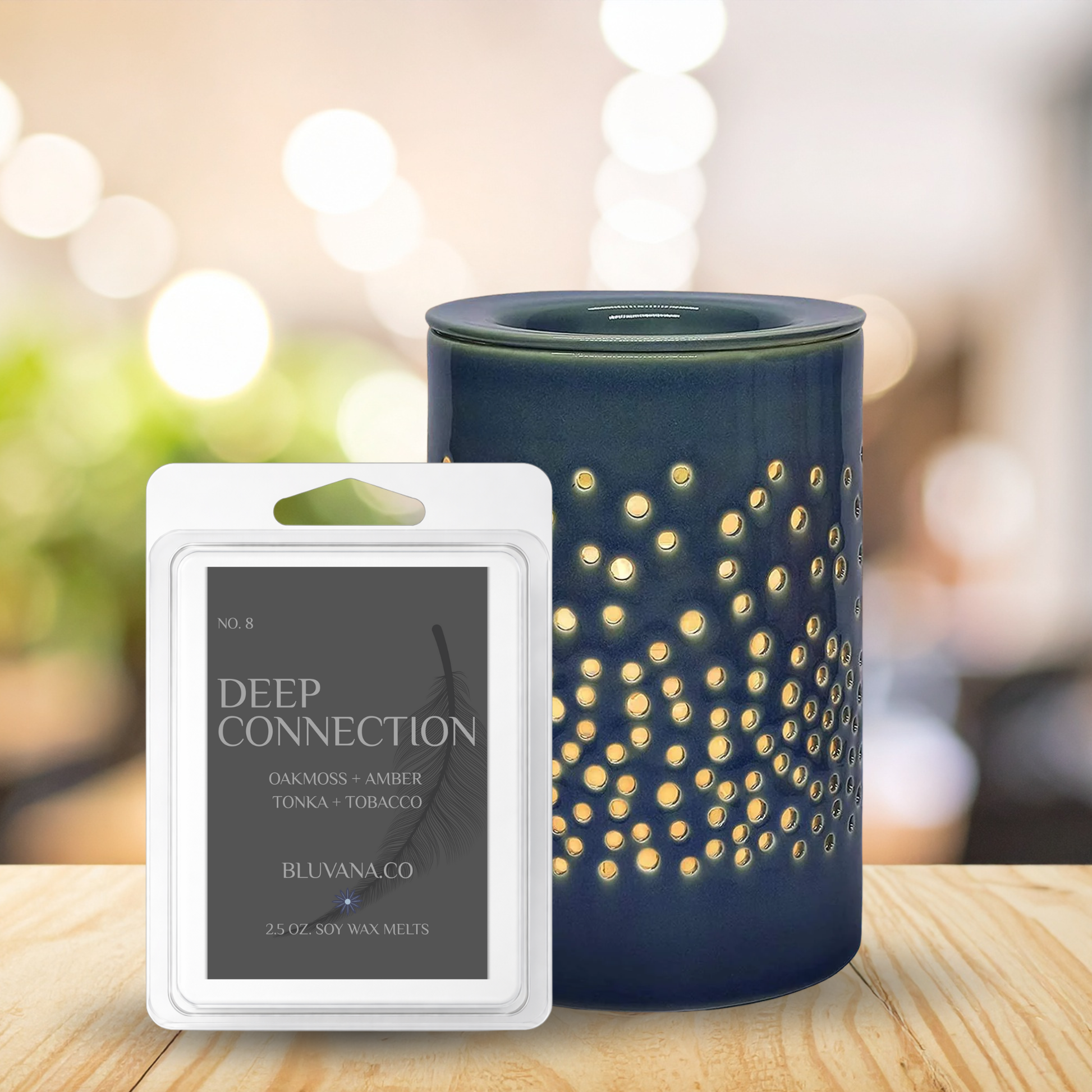 Blue diffuser with decorative pattern and Bluvana Co. wax melt packaging on a wooden surface.