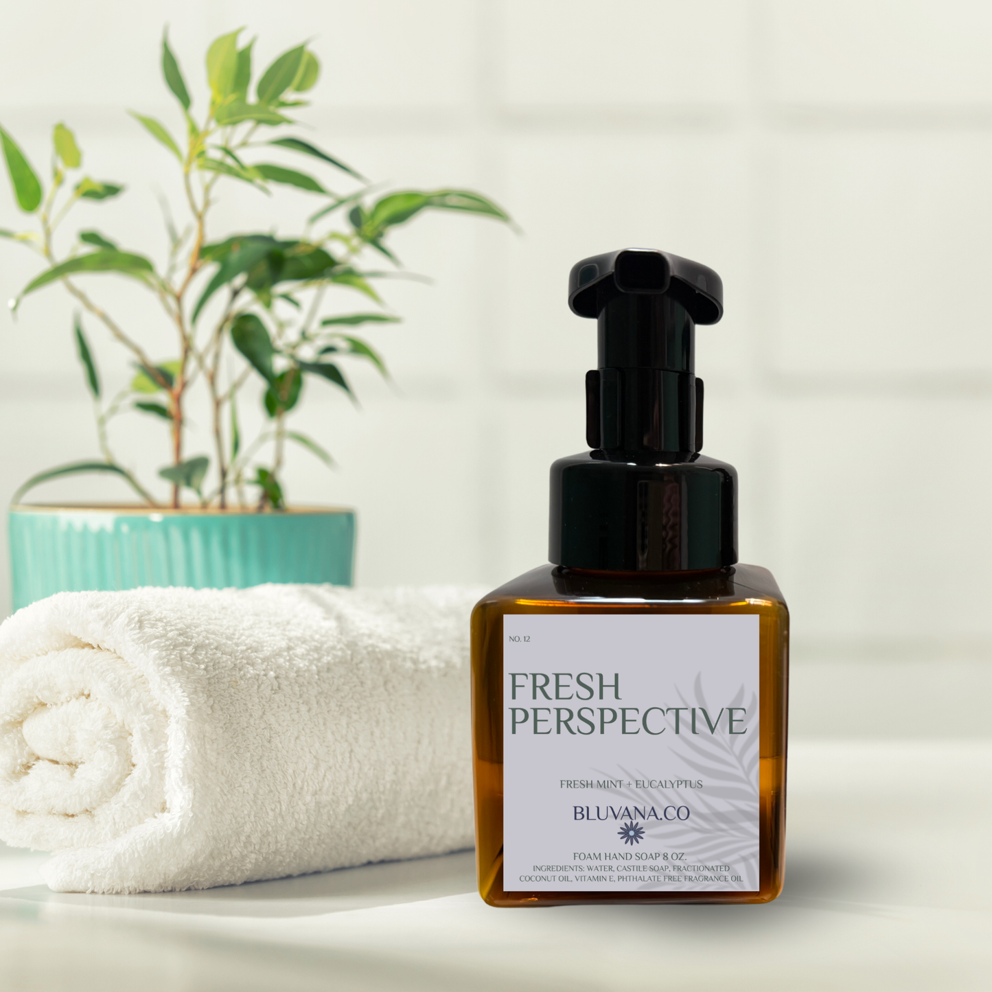 Bottle of 'Fresh Perspective' product by Belivana Co. on a white surface with a towel and plant in the background.