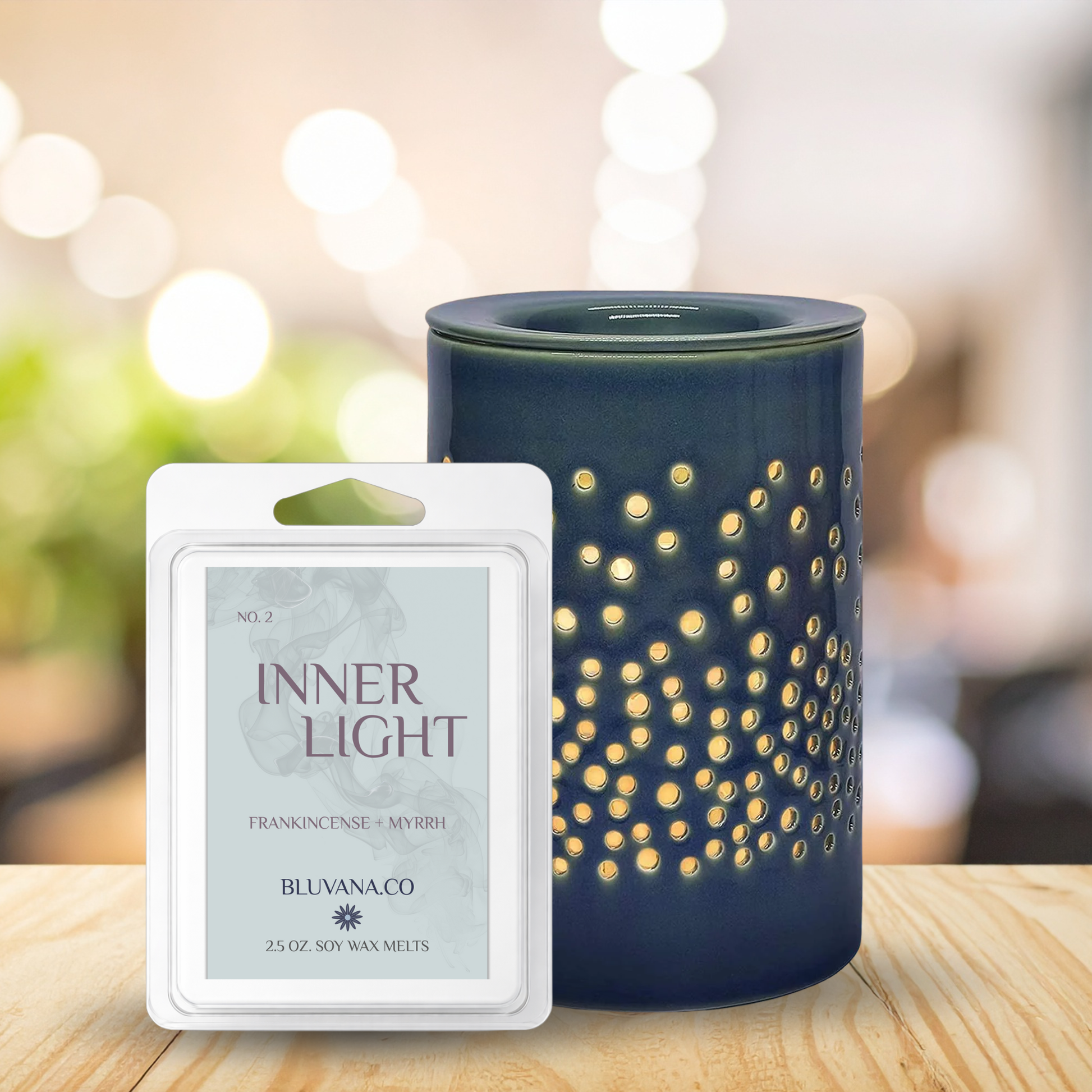 Blue wax warmer with decorative design next to a 'Inner Light' wax melt packaging on a wooden surface.
