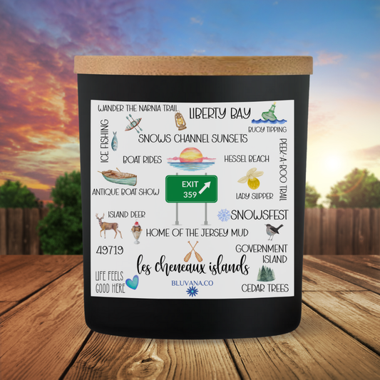 Black candle with a scenic design on a wooden surface with a sunset background