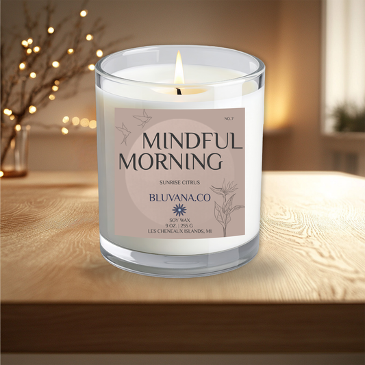 Candle labeled 'Mindful Morning' by Bluvana Co on a wooden surface with a blurred background