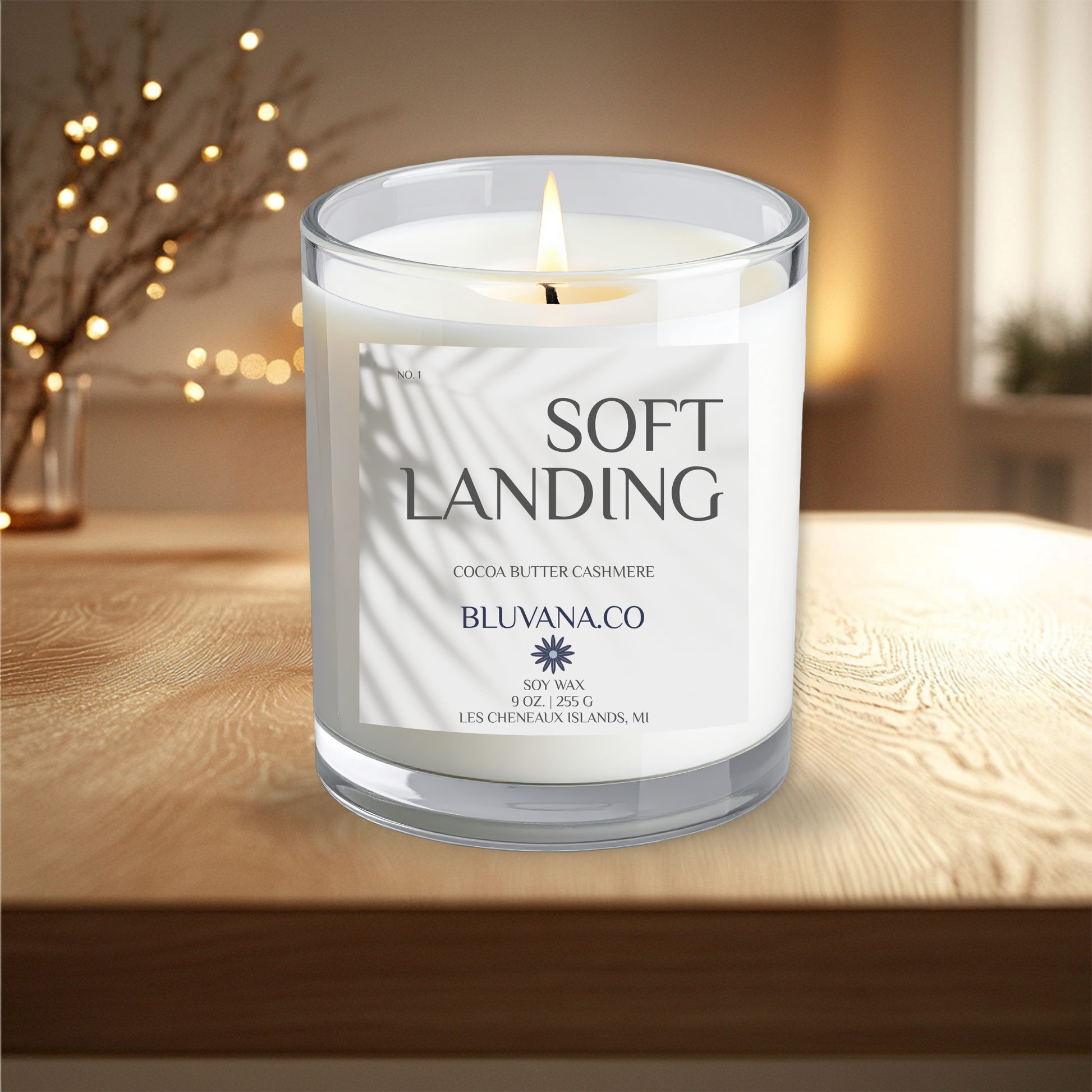 Candle labeled 'Soft Landing' by BLUVANA.CO on a wooden surface with a blurred background