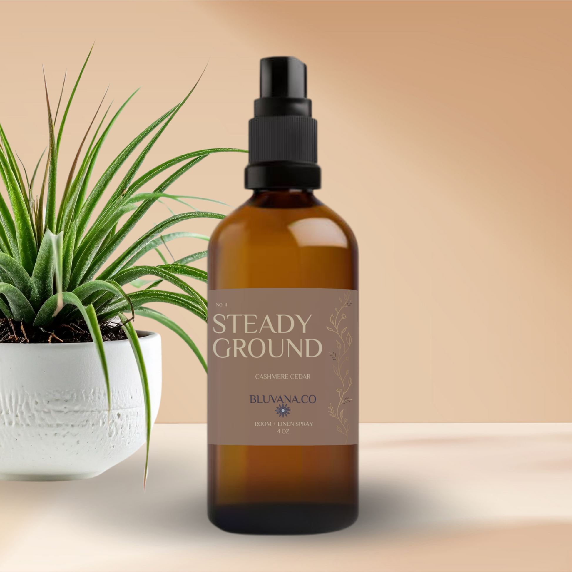Brown spray bottle labeled 'Steady Ground' by Bluvanaco with a plant on a beige background