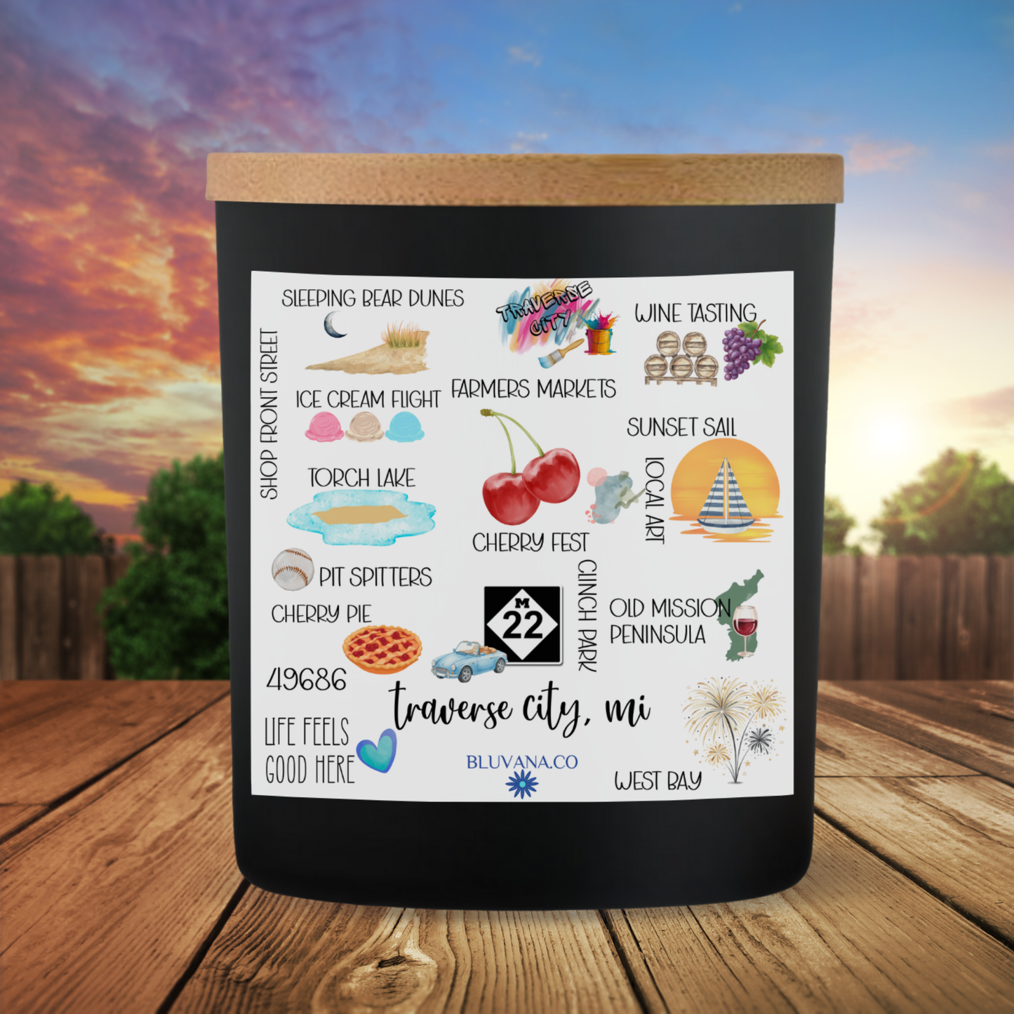 Decorative candle label of Traverse City with illustrations and text on a wooden surface with a sunset background