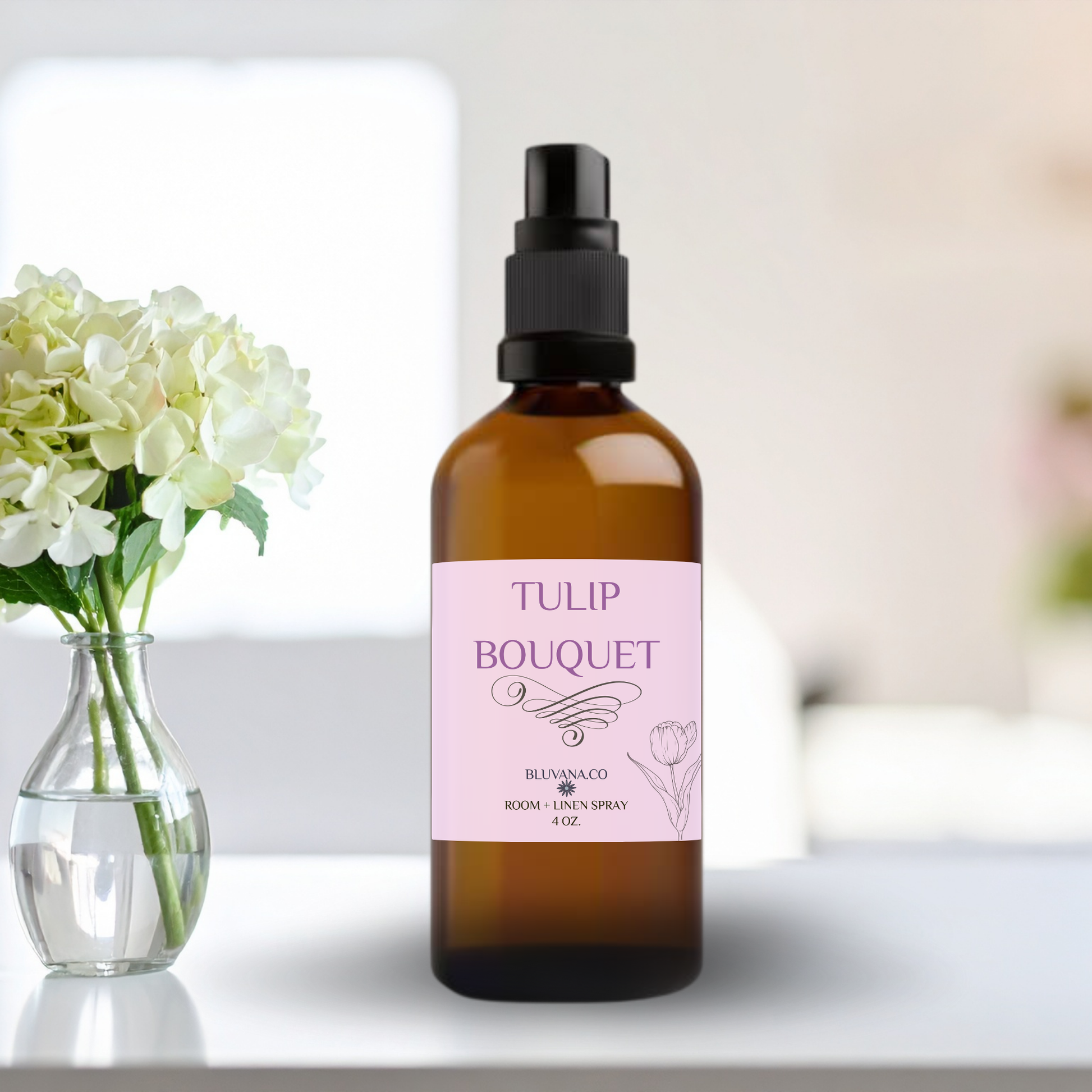 Room Spray in an amber color glass bottle with a pink label that reads Tulip Bouquet with a bouquet of flowers sitting next to it. 