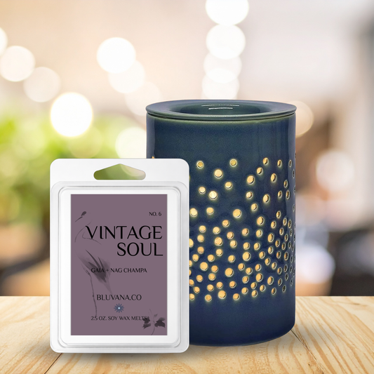 Blue diffuser with decorative pattern and 'Vintage Soul' wax melt packaging on a wooden surface.