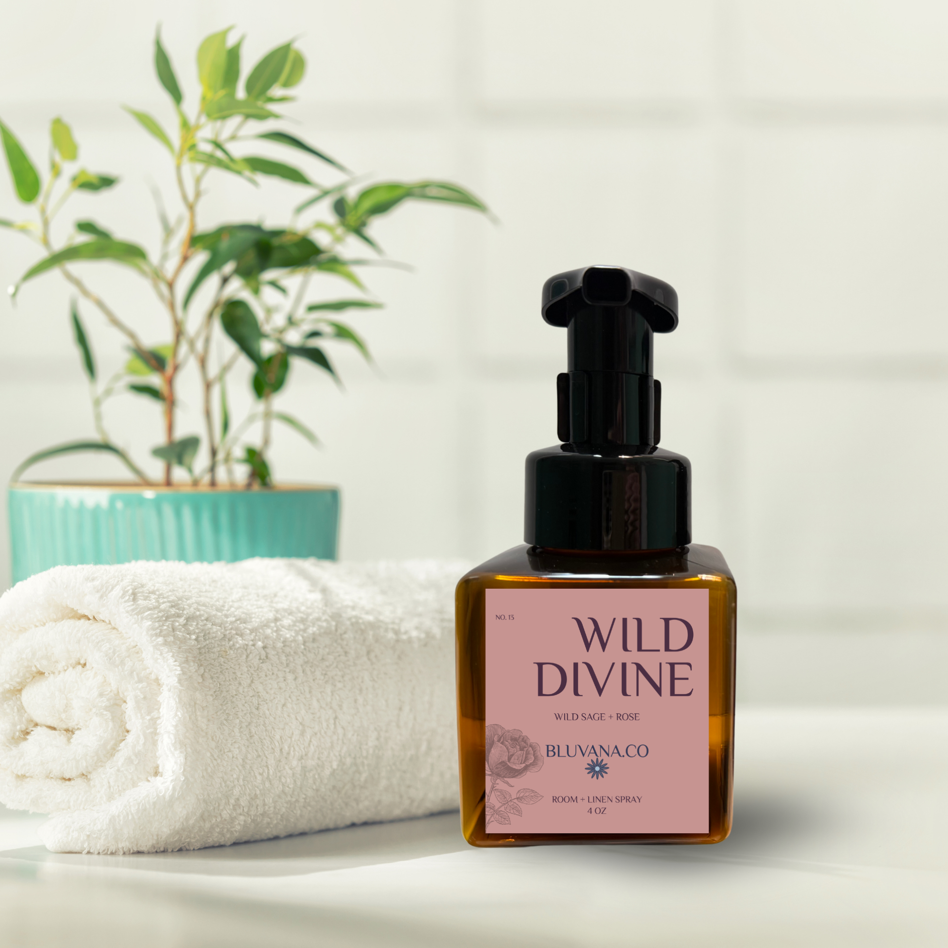 Bottle of 'Wild Divine' product by Bluvana Co on a white surface with a towel and plant in the background.